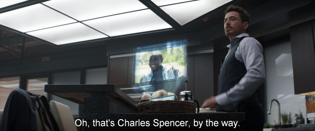 Tony Stark projects an image of a young man from his phone.