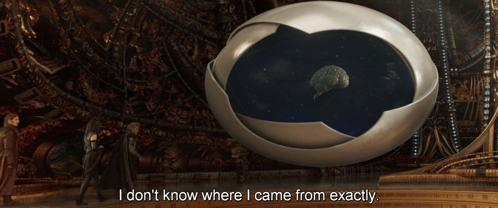 Ego stands in front of massive displays in his cathedral. 